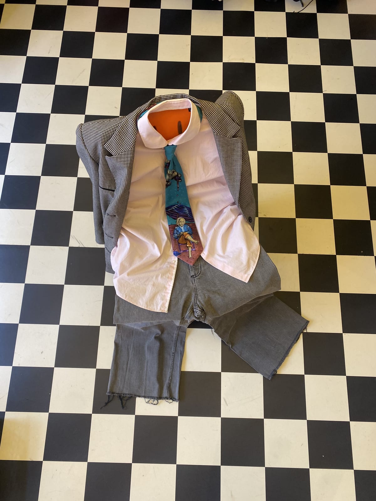 Upgecyceltes Outfit aus Hemd, Krawatte und Hose auf Schachbrettboden