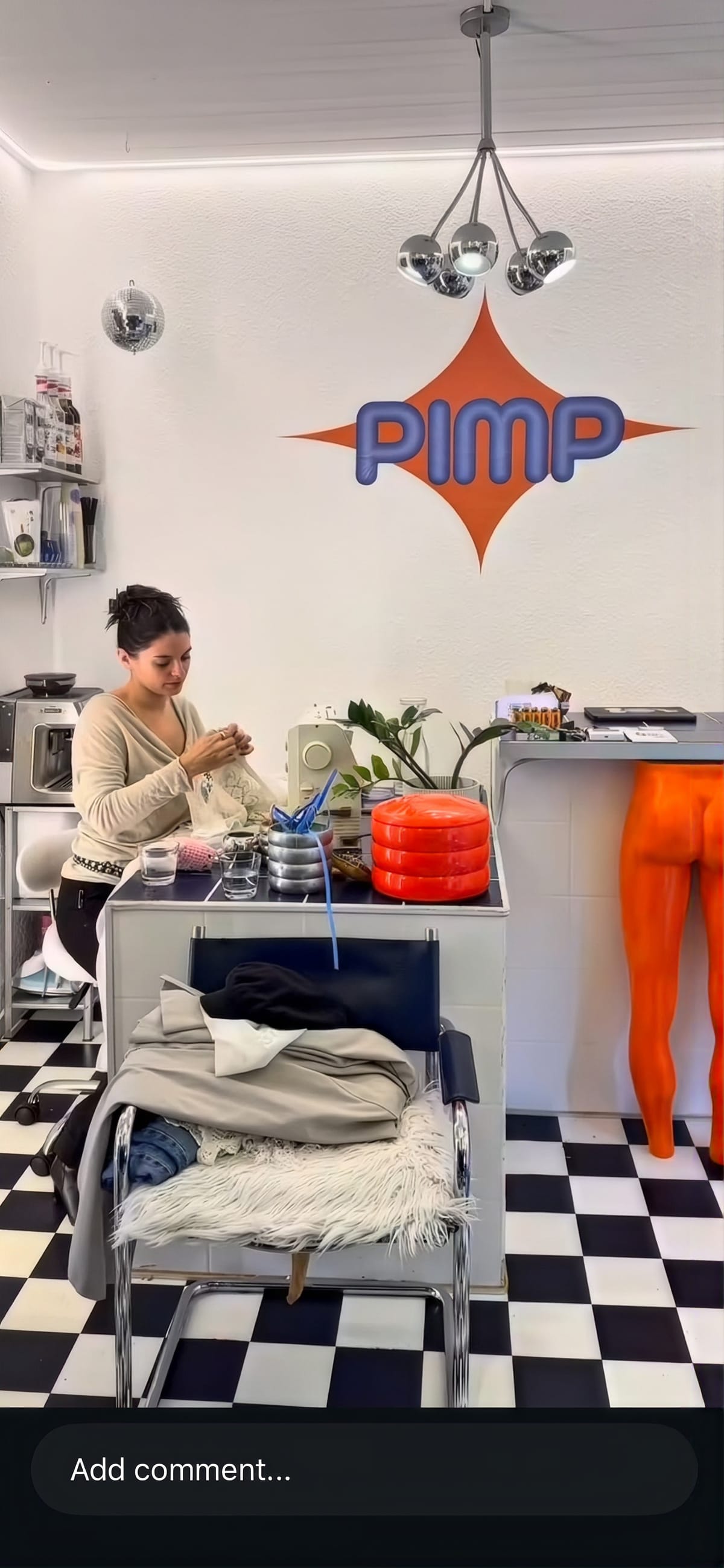 Alea arbeitet an der Theke im Laden, dahinter das PIMP-Logo an der Wand